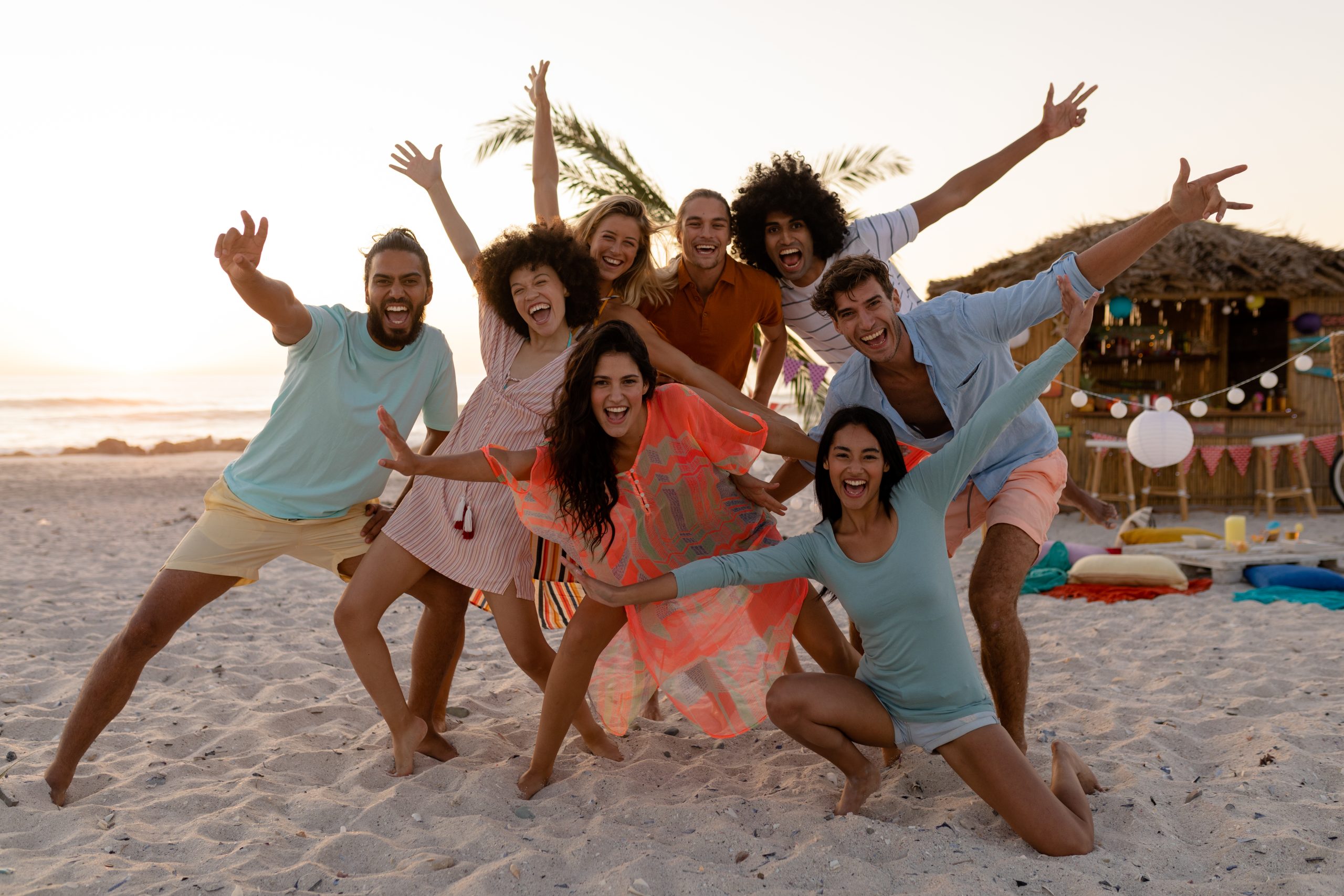 A multi-ethnic group of friends enjoying their time together, posing to a photo, looking at the camera and smiling